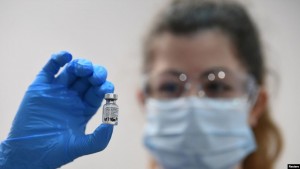 A member of medical staff holds a phial of the Pfizer